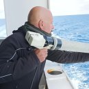 An operator throws an XBT probe into the sea